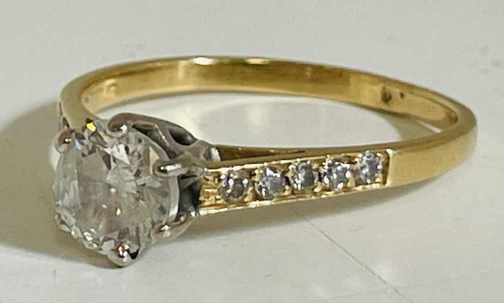 Guld: solitaire ring udført i 18kt./750 prydet m. stor diamant samt paveret m. 10 mindre diamanter