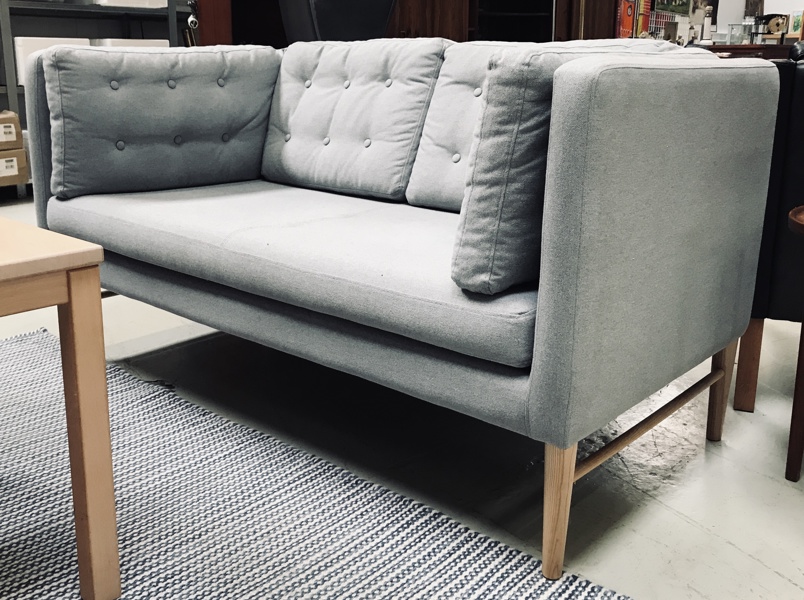 Ilva 2-pers sofa beklædt i lysgråt stof på lyse ben af bøgetræ