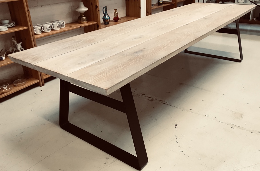 Plankebord af lyspigmenteret egeplanker (2) prydet formbøjet af stel/ben af sortlakeret stål 