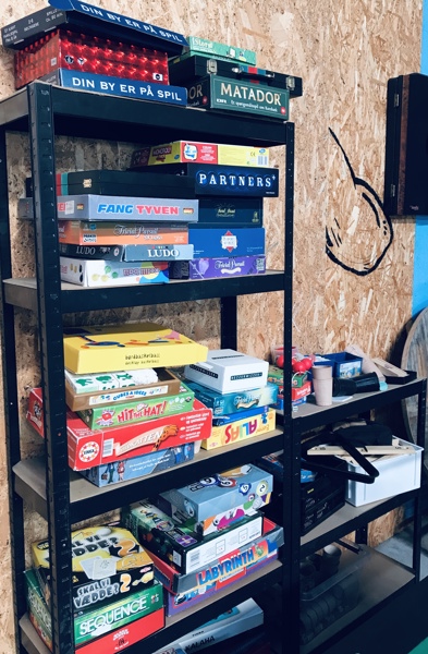 +M: Reol m. mange brætspil (Bezzerwizzer, Sequence, Partners, Matador, Trivial Pursuit, Ludo, Skal vi vædde, Vildkatten m.fl.),  elektronisk dart, stigegolf, cafébord m.v.