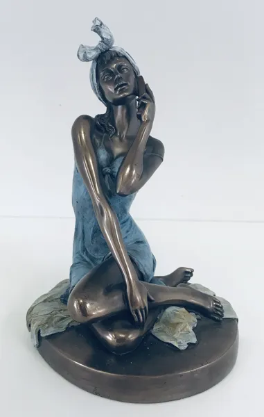 Veronese metal figur, skabt af koldstøbt bronze og vinyl, siddende på en bronzebase. Forestiller en siddende kvinde i en blå kjole, der taler i telefon.