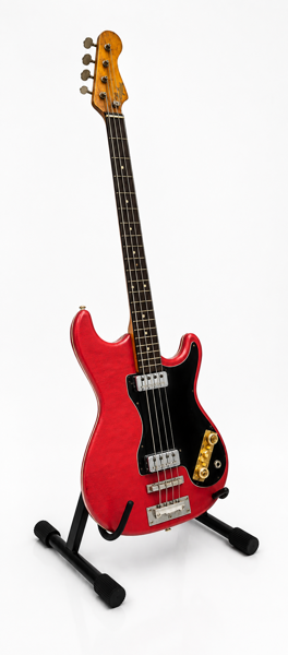 Höfner 1960'erne solid-body elbas i en rød finish med sort pickguard, fremstillet i Tyskland. Med 2 stk. IMG Stage Line guitarvægophæng.
