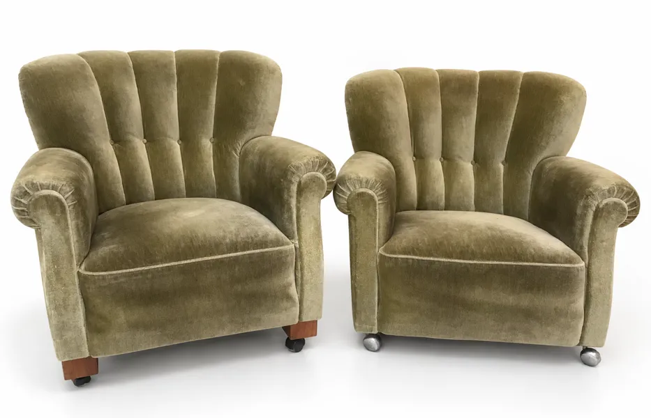 Danske Art Deco overpolstrede lænestole, med rillet ryg, indsyede knapper og rullede armlæn samt anrettet på hjul. Betrukket med grønt velour, med ben af bejdset bøg.